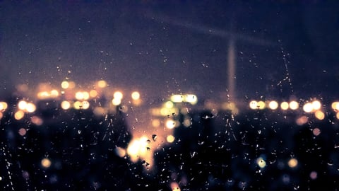 Defocused city lights glowing across a dark night skyline.