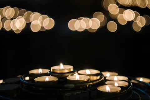 Candles glowing in the foreground with soft golden lights behind them.